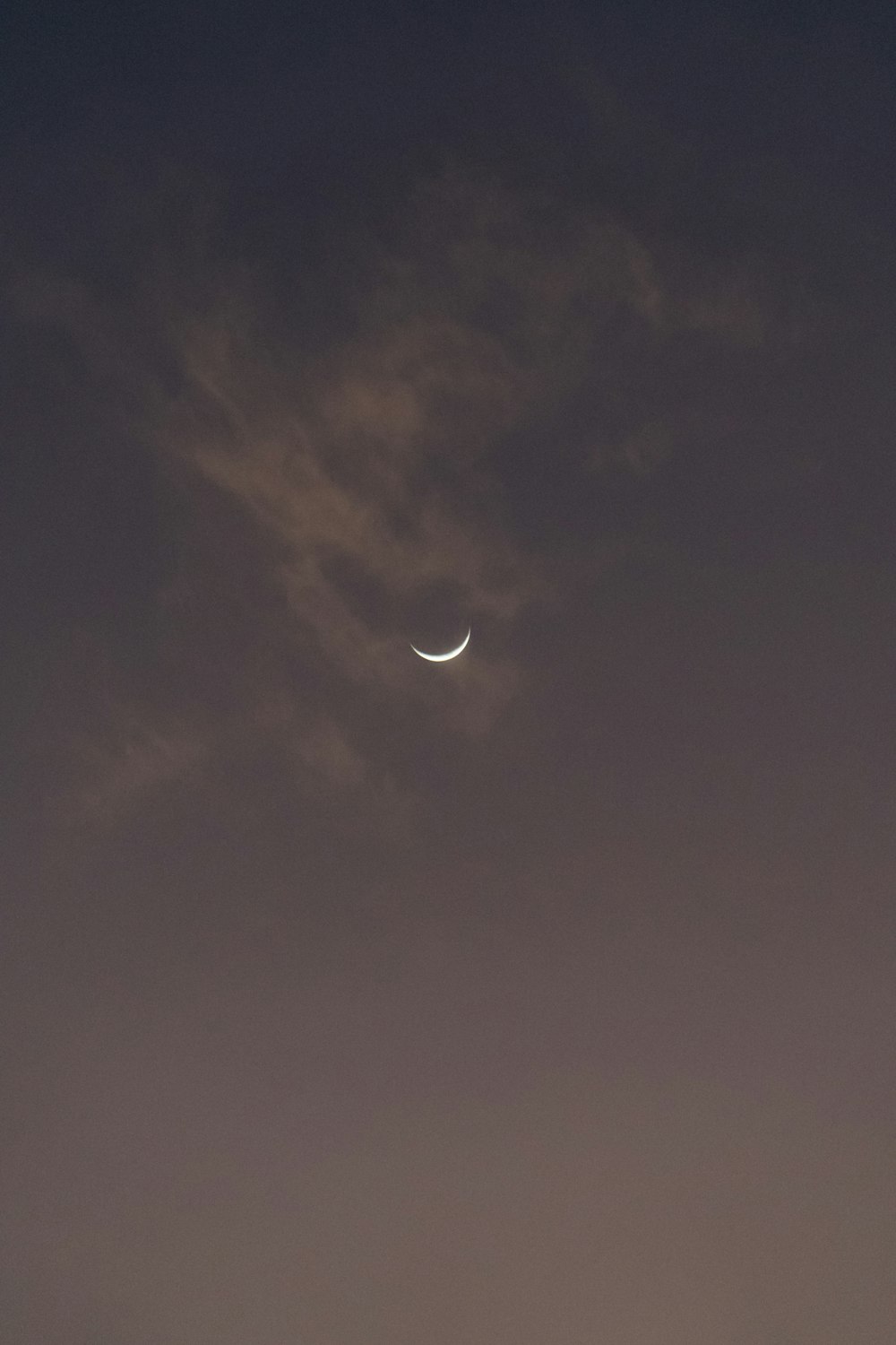 a crescent moon is seen in the night sky