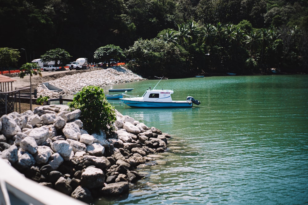 a boat floating on top of a lake next to a shore