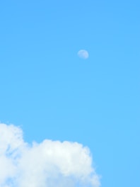 a plane flying through a blue sky with clouds