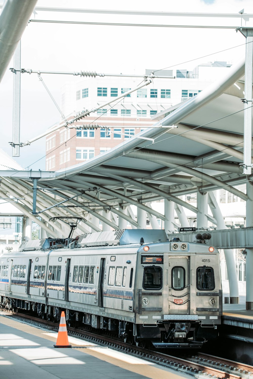 a silver train pulling into a train station