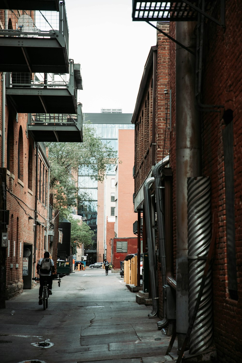 a man riding a bike down a street next to tall buildings