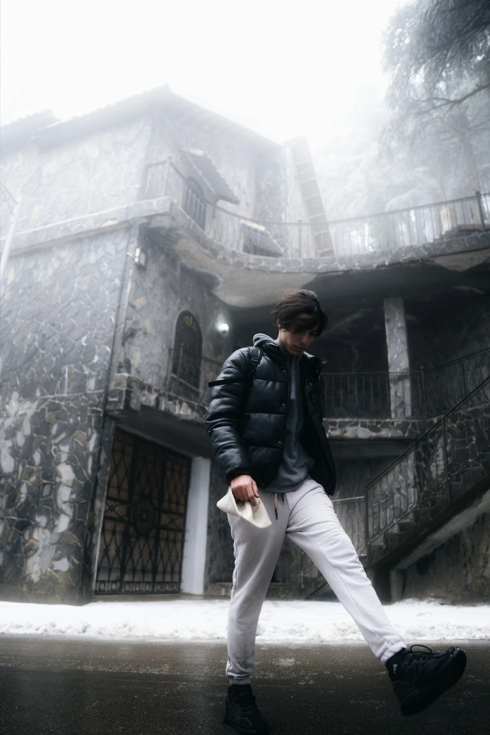 a man walking down a street in front of a building