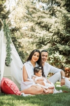 A family happily setting up an air mattress outdoors for a camping trip.