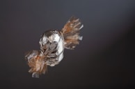 Close-up of a candy wrapper being peeled back to reveal a chewy treat.