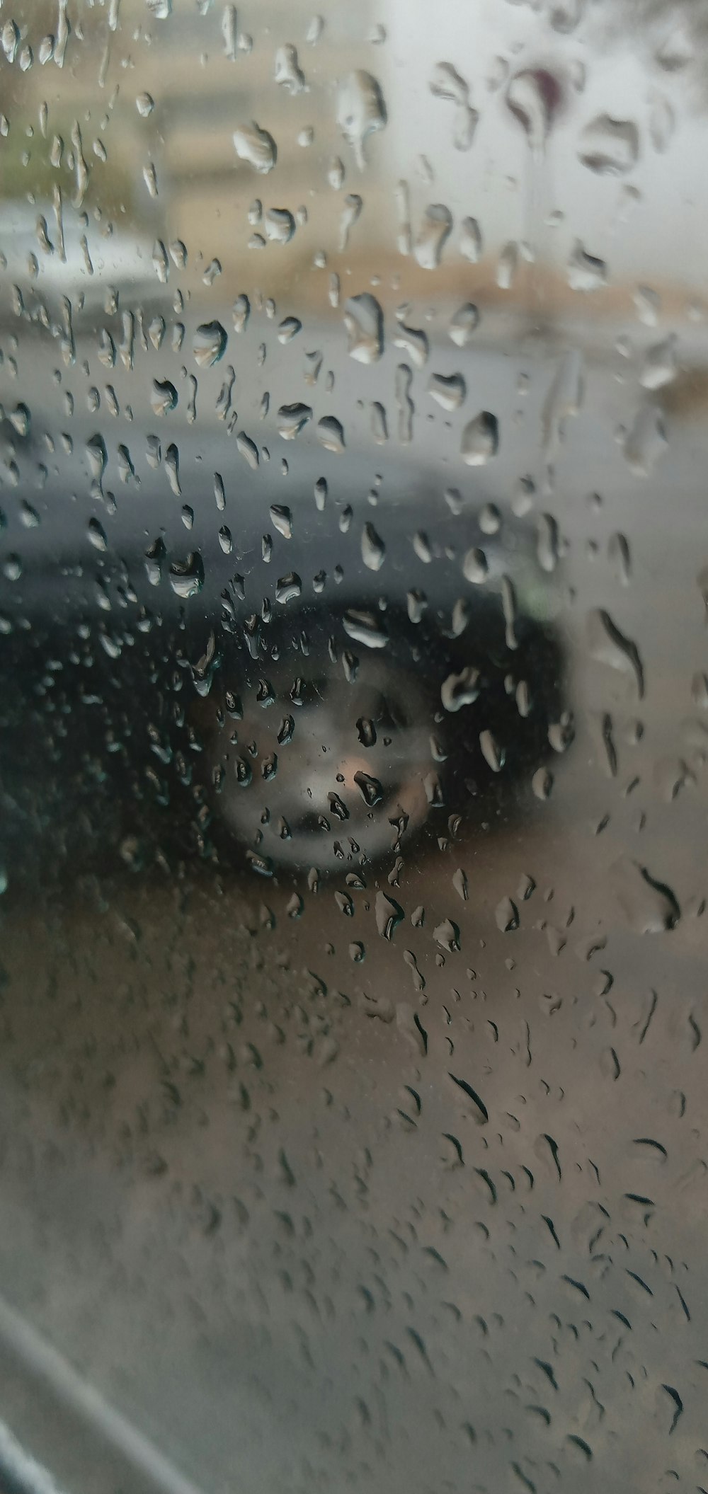 a car is seen through a rain covered window