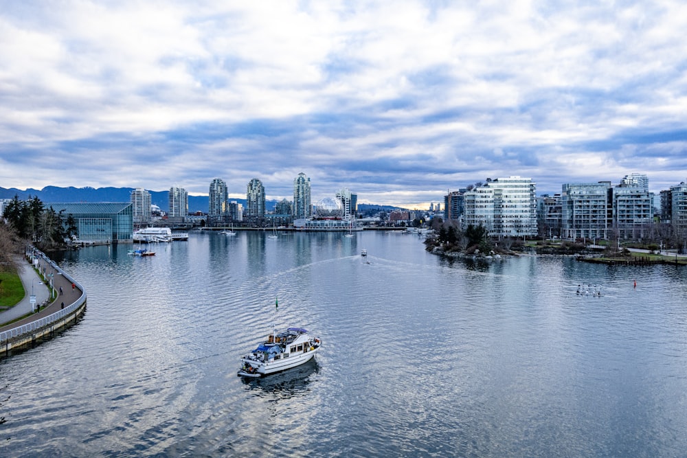 a boat traveling down a river next to a city