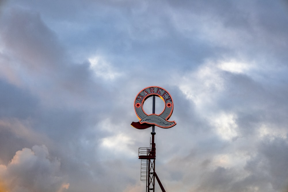 a sign on top of a building under a cloudy sky