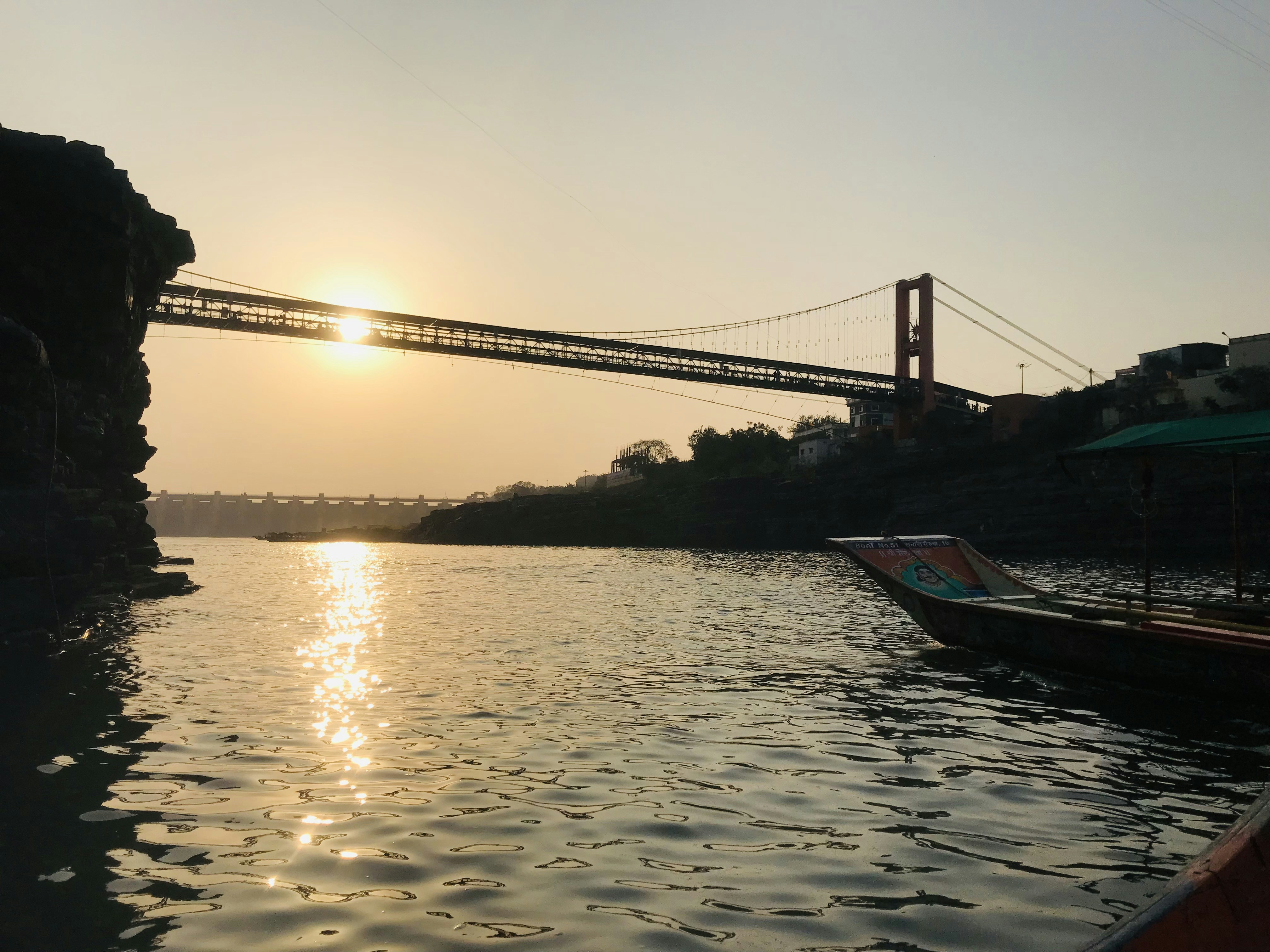 a bridge over a body of water with a boat in the foreground