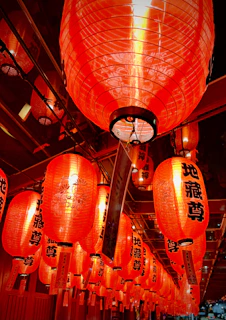 A vibrant family reunion with multiple generations sharing stories and laughter under red lanterns.