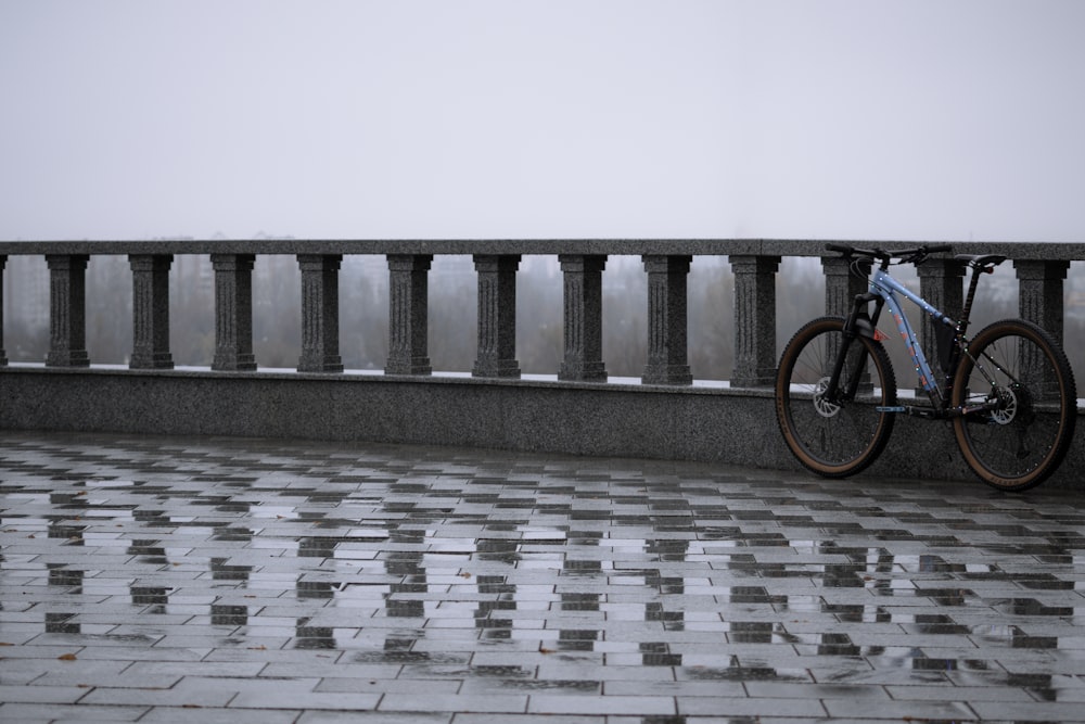 a bicycle parked on a bridge in the rain