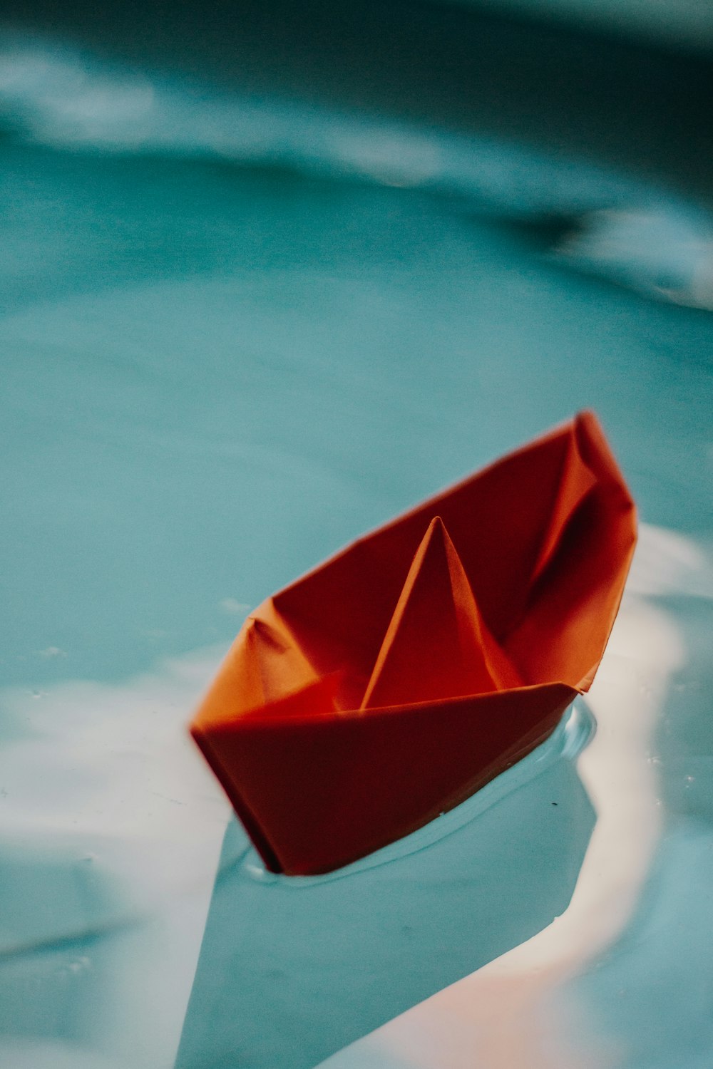 a paper boat floating on top of a body of water