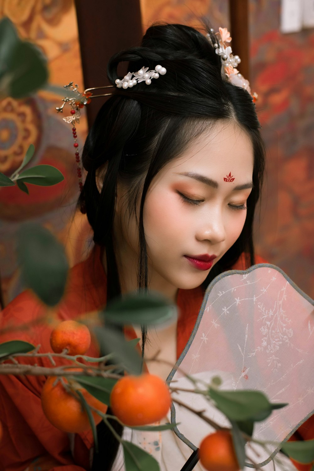 a woman in a red dress holding a fan