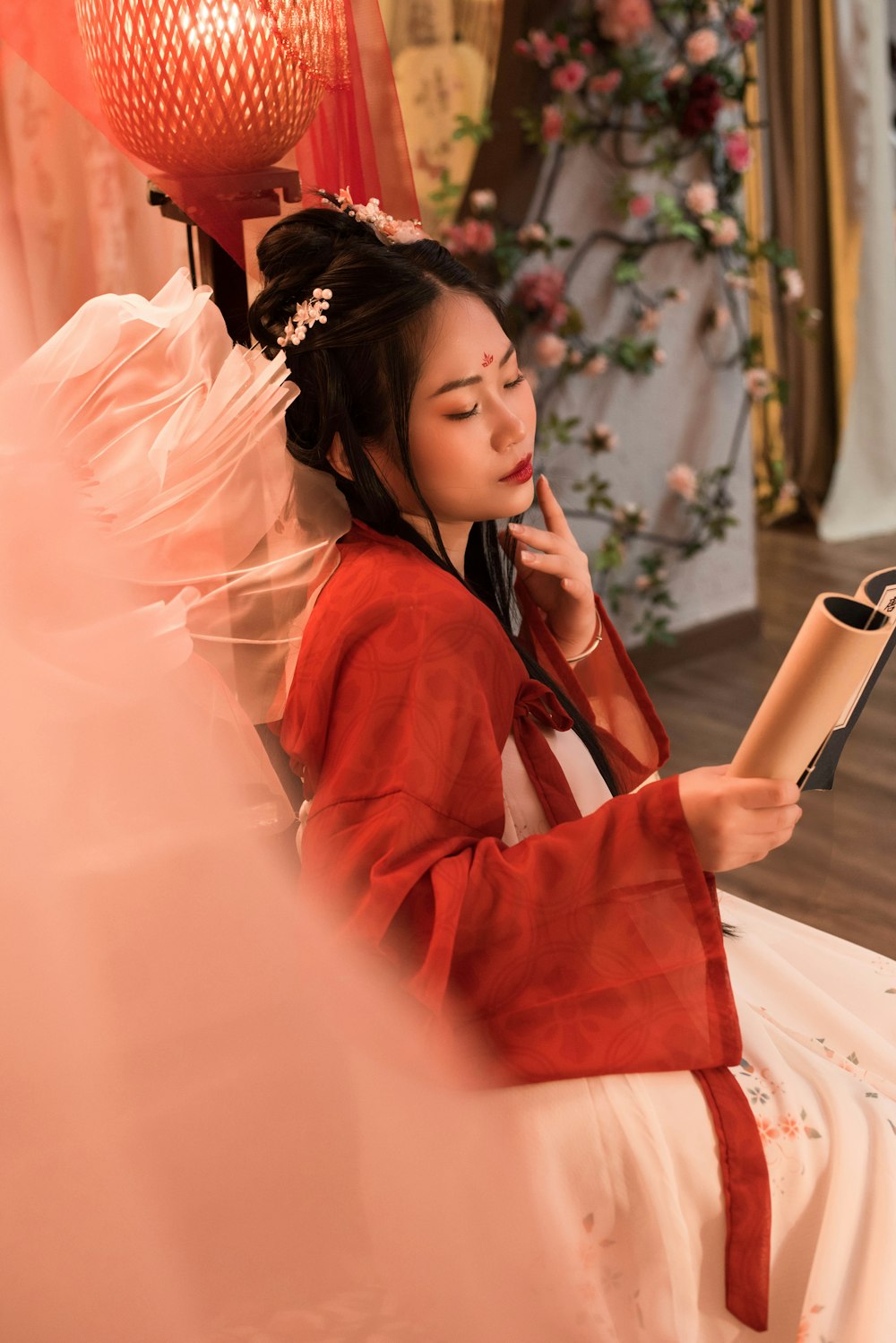 a woman in a red kimono reading a book