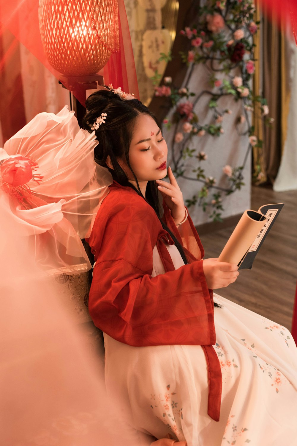 a woman in a red kimono reading a book