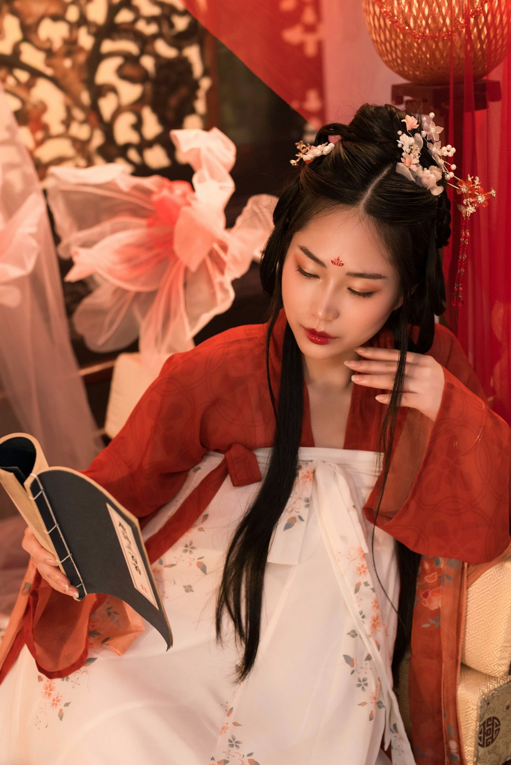 a woman in a red kimono reading a book