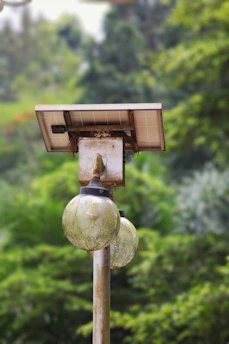 A solar-powered light illuminating a rural village pathway at dusk, symbolizing hope and sustainable energy.