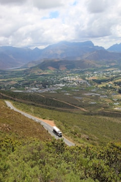 a car driving down a road with mountains in the background