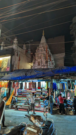A vibrant local market bustling near a temple entrance at dawn.