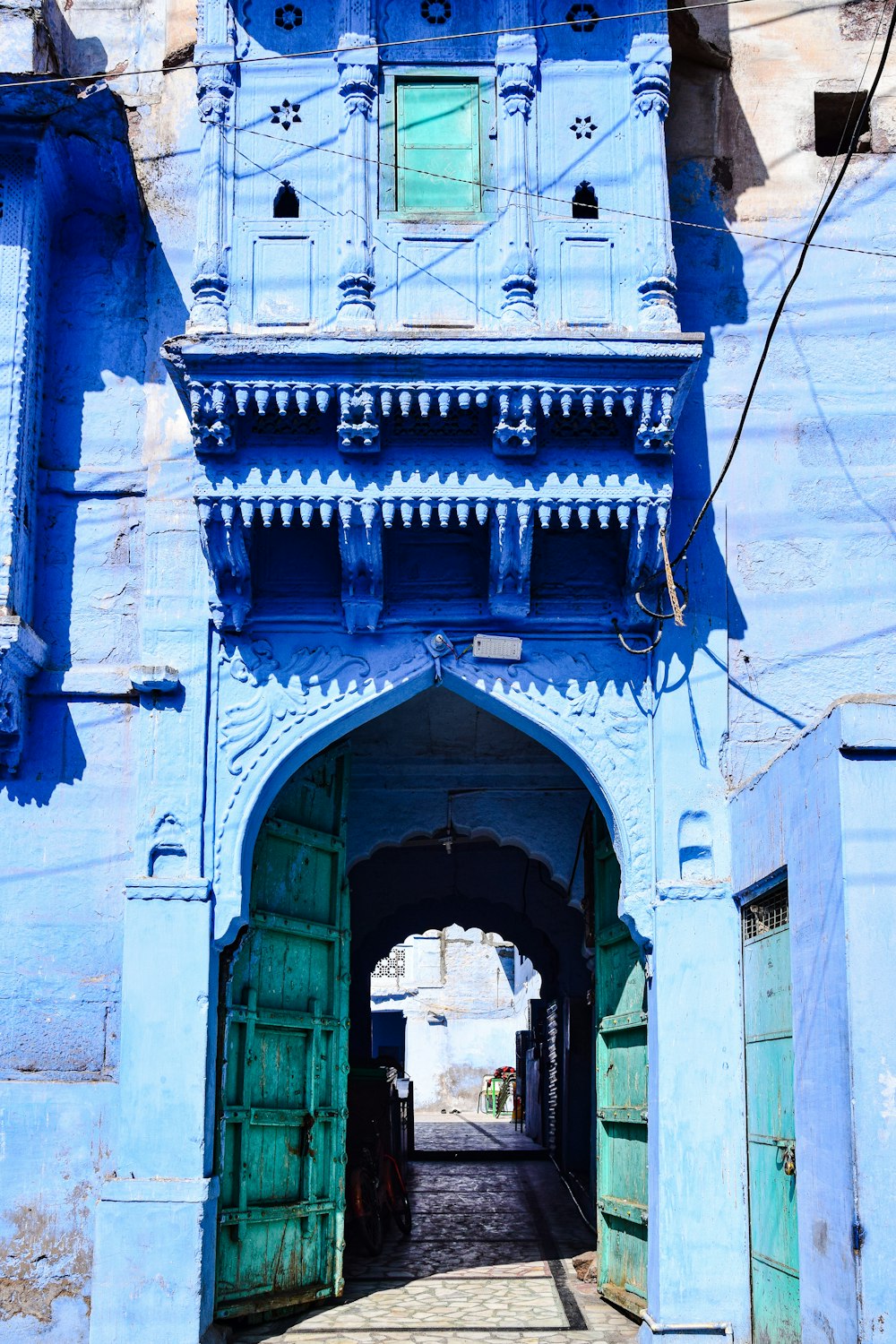 a blue building with a doorway and a clock on it