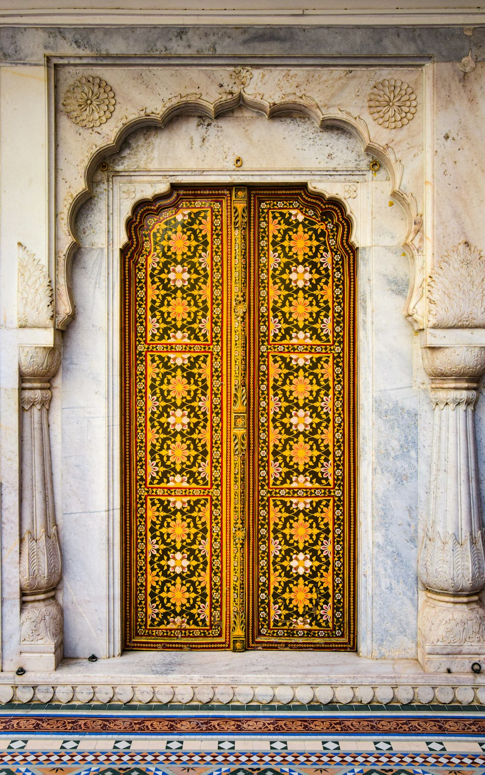 a yellow door with ornate carvings on the side of a building
