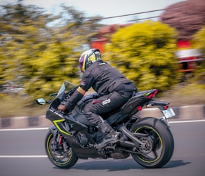 An action shot of a rider in motoluxe gear speeding down a highway.