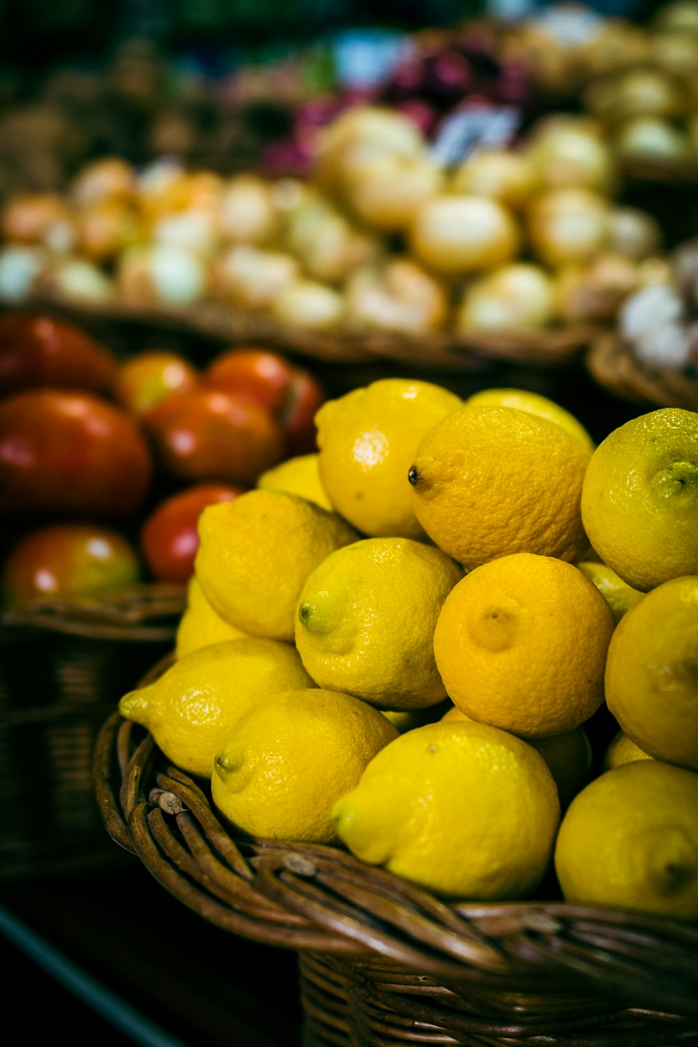 a pile of lemons sitting on top of a pile of apples