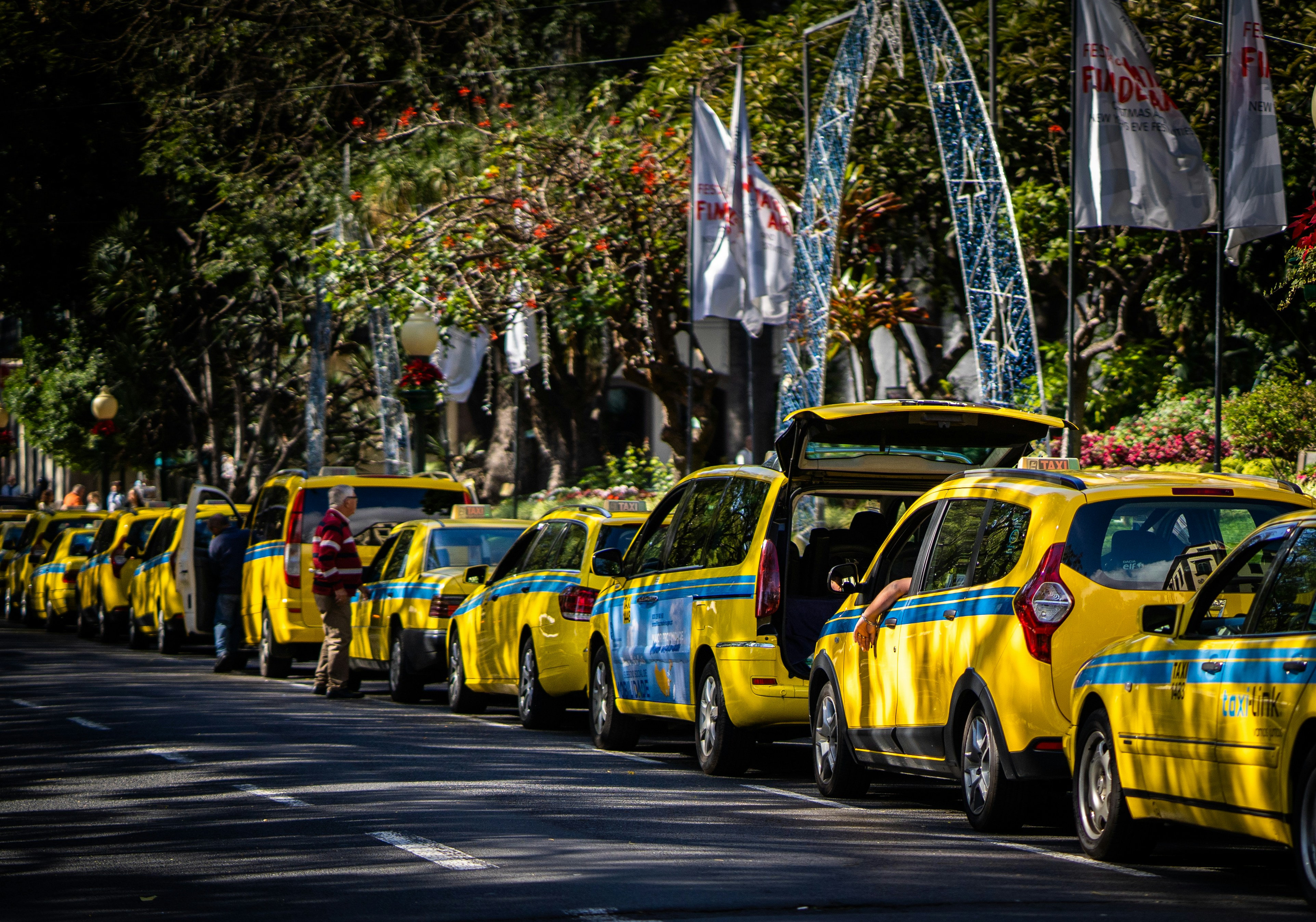 a line of taxis parked on the side of a road