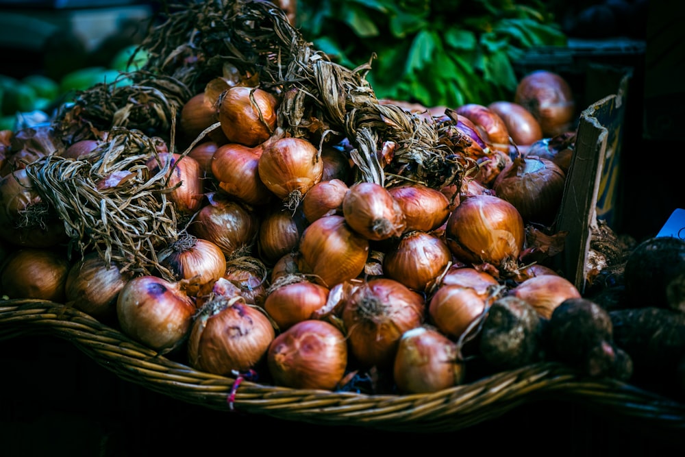 a basket filled with lots of onions on top of a table