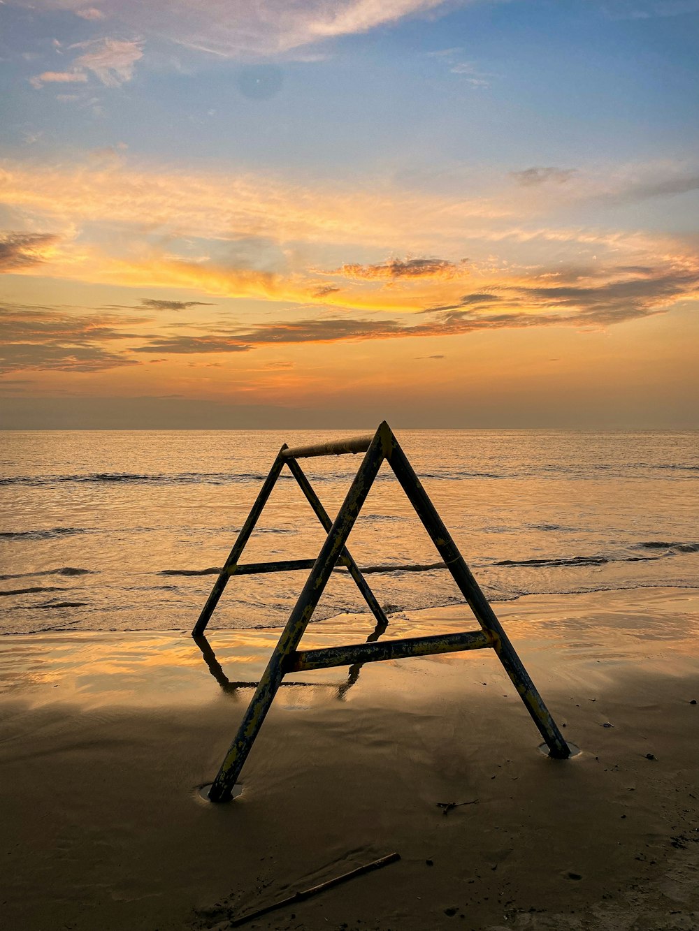 a wooden structure sitting on top of a sandy beach