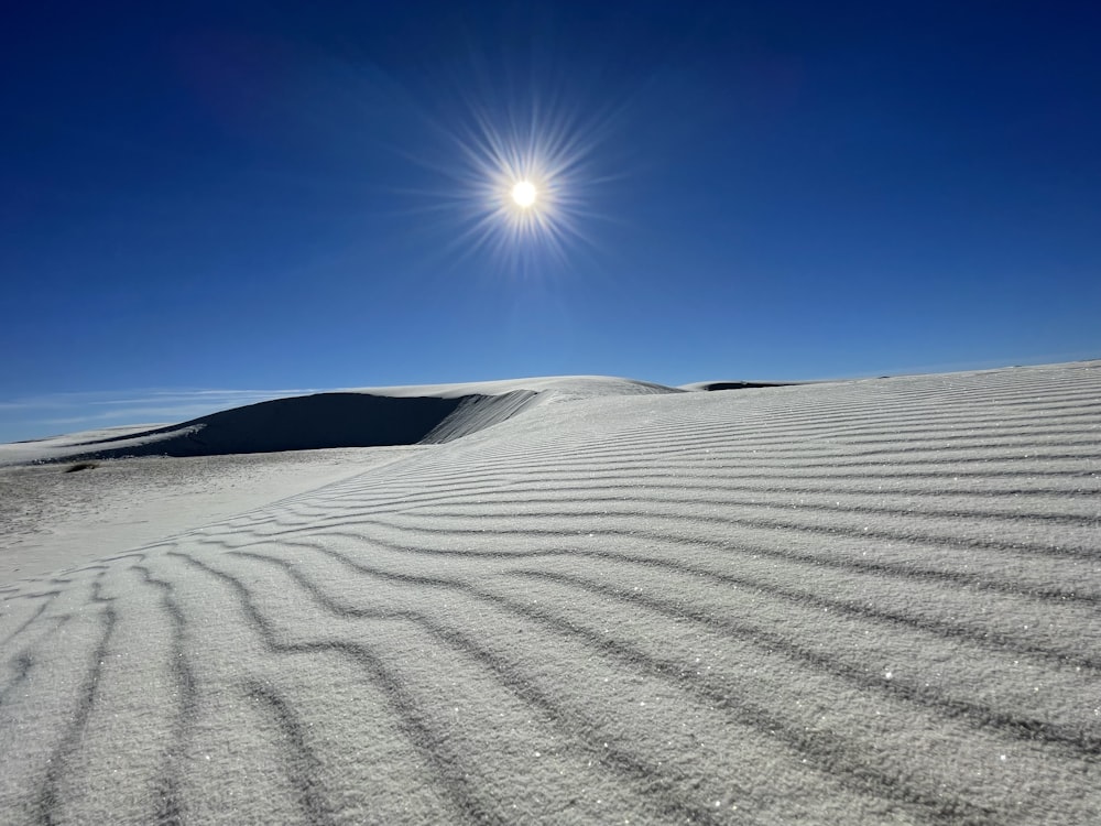 the sun shines brightly over a sand dune