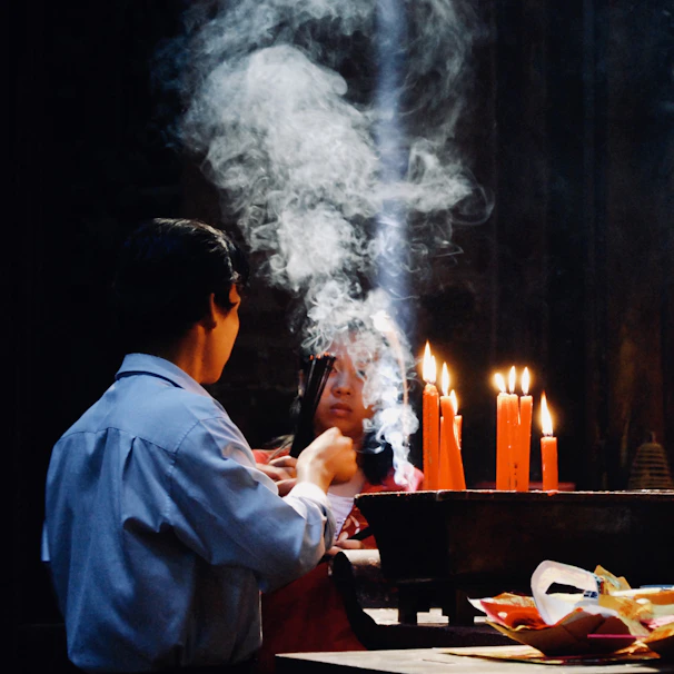 The grand ritualist performing a love spell surrounded by rose petals and golden incense smoke