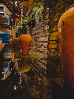 A large handcrafted terracotta jar placed elegantly in a sunlit luxury villa garden.