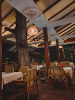 An outdoor dining area featuring clean lines, natural timber elements, and soft purple ambient lighting creating a cozy atmosphere.