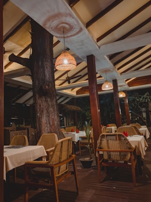 An outdoor dining area featuring clean lines, natural timber elements, and soft purple ambient lighting creating a cozy atmosphere.