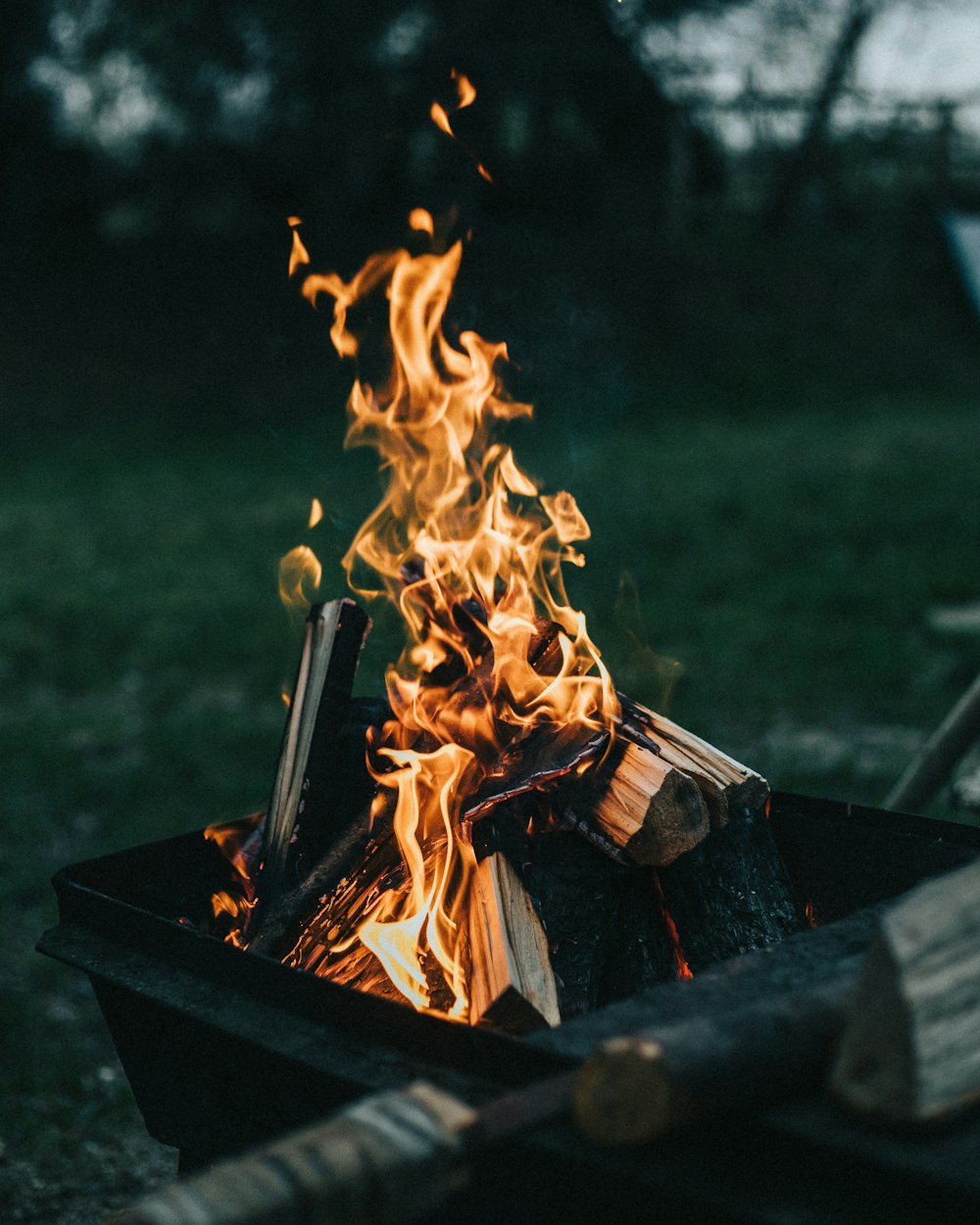 a fire burning in a fire pit in a field