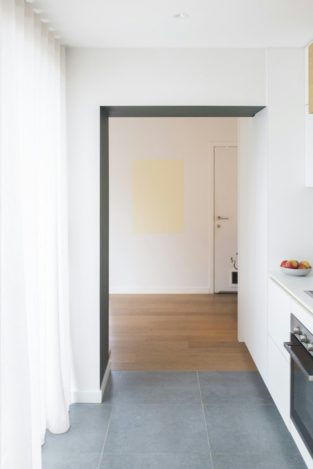 a kitchen with white walls and wood floors