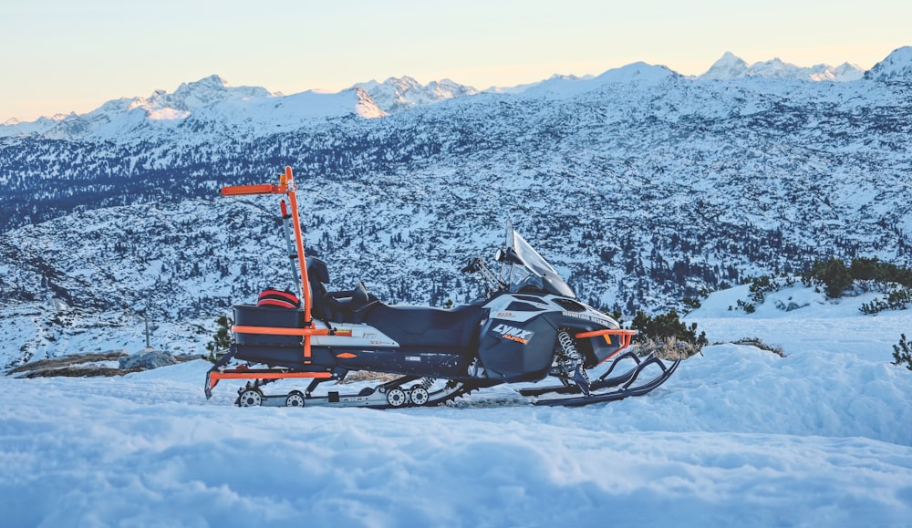 a snowmobile is parked in the snow near a mountain