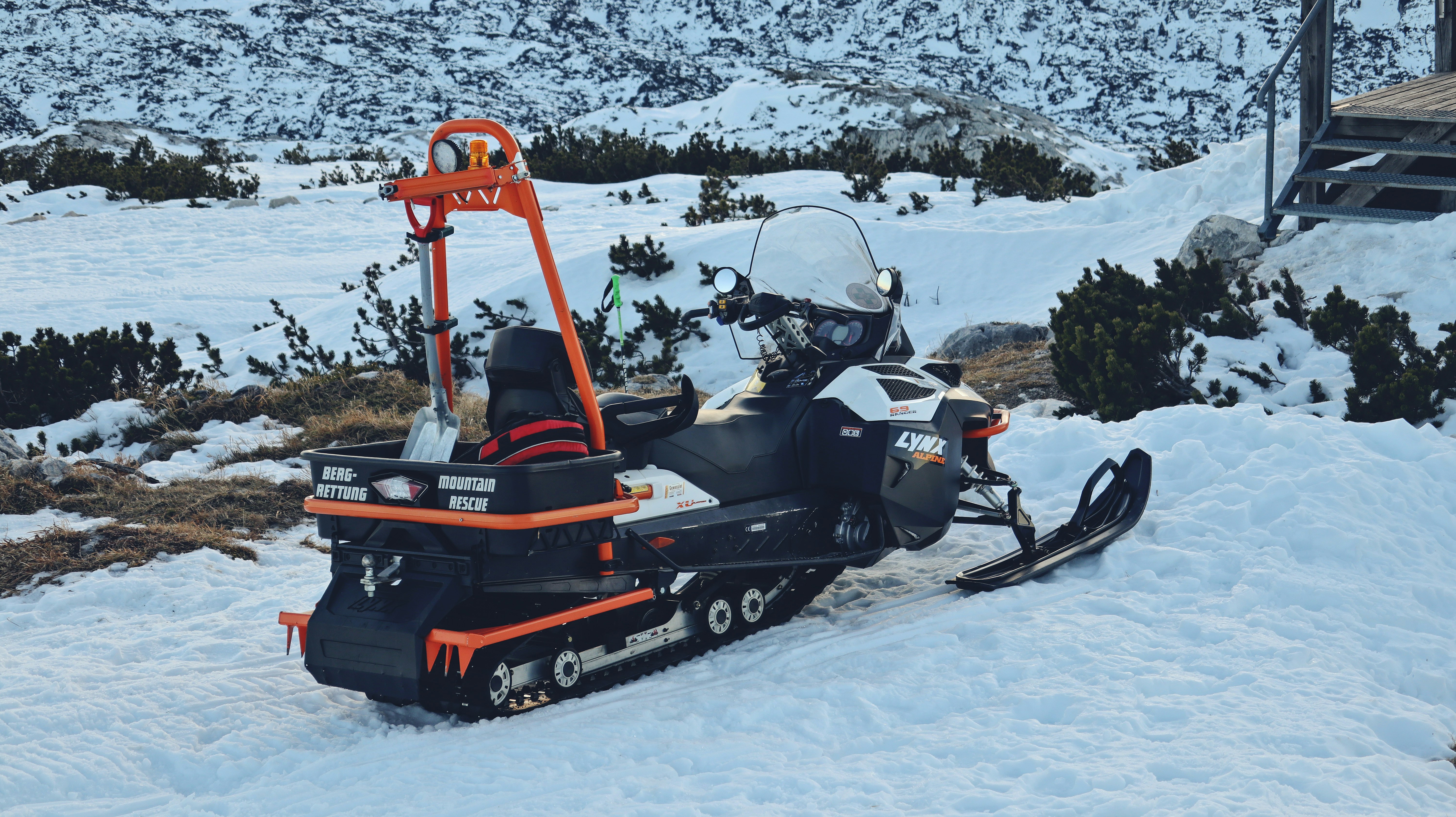 A snowmobile parked in the snow with a ski lift attached to it photo ...