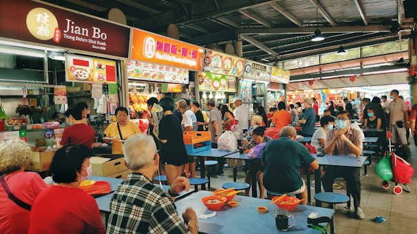 A vibrant food court in a mall, featuring colorful stalls and happy customers enjoying meals.