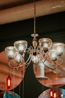 An elegant chandelier hanging in a modern living room with warm ambient lighting.