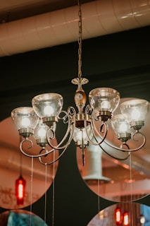 Elegant chandelier with multiple bulbs hanging from a high ceiling in a dining room