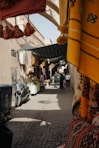a narrow street with people walking around it