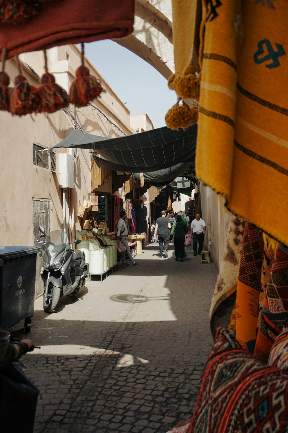 a narrow street with people walking around it