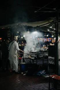a group of people standing around a grill