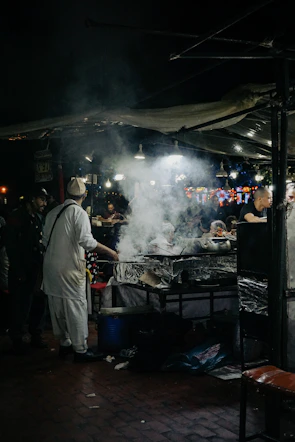 a group of people standing around a grill