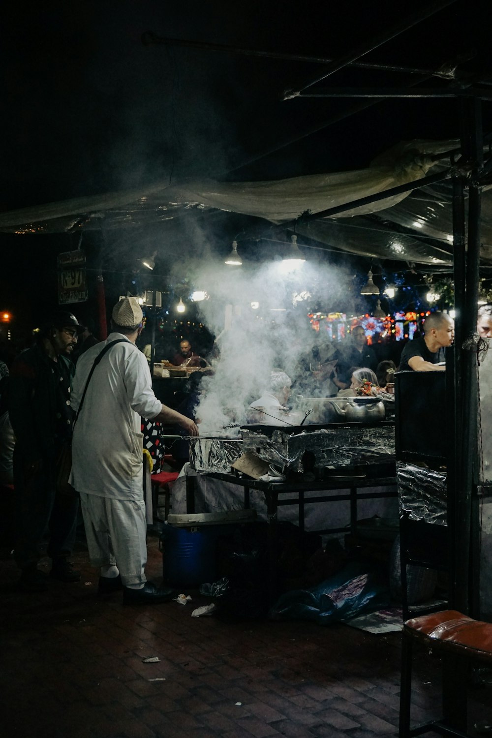 a group of people standing around a grill