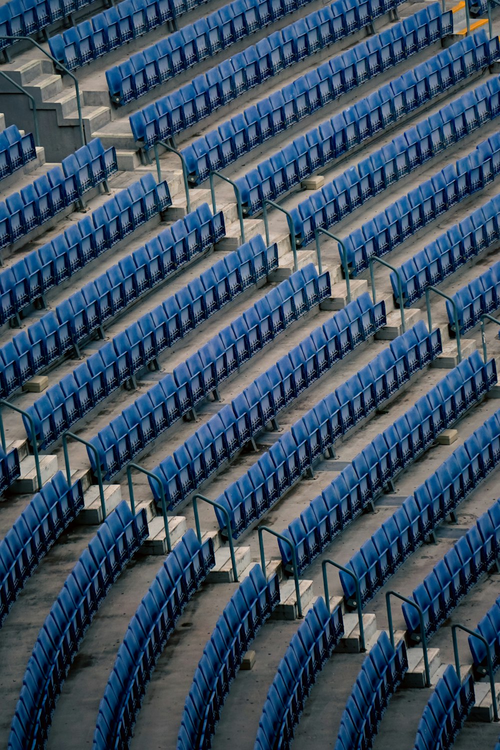 a row of empty blue seats in a stadium