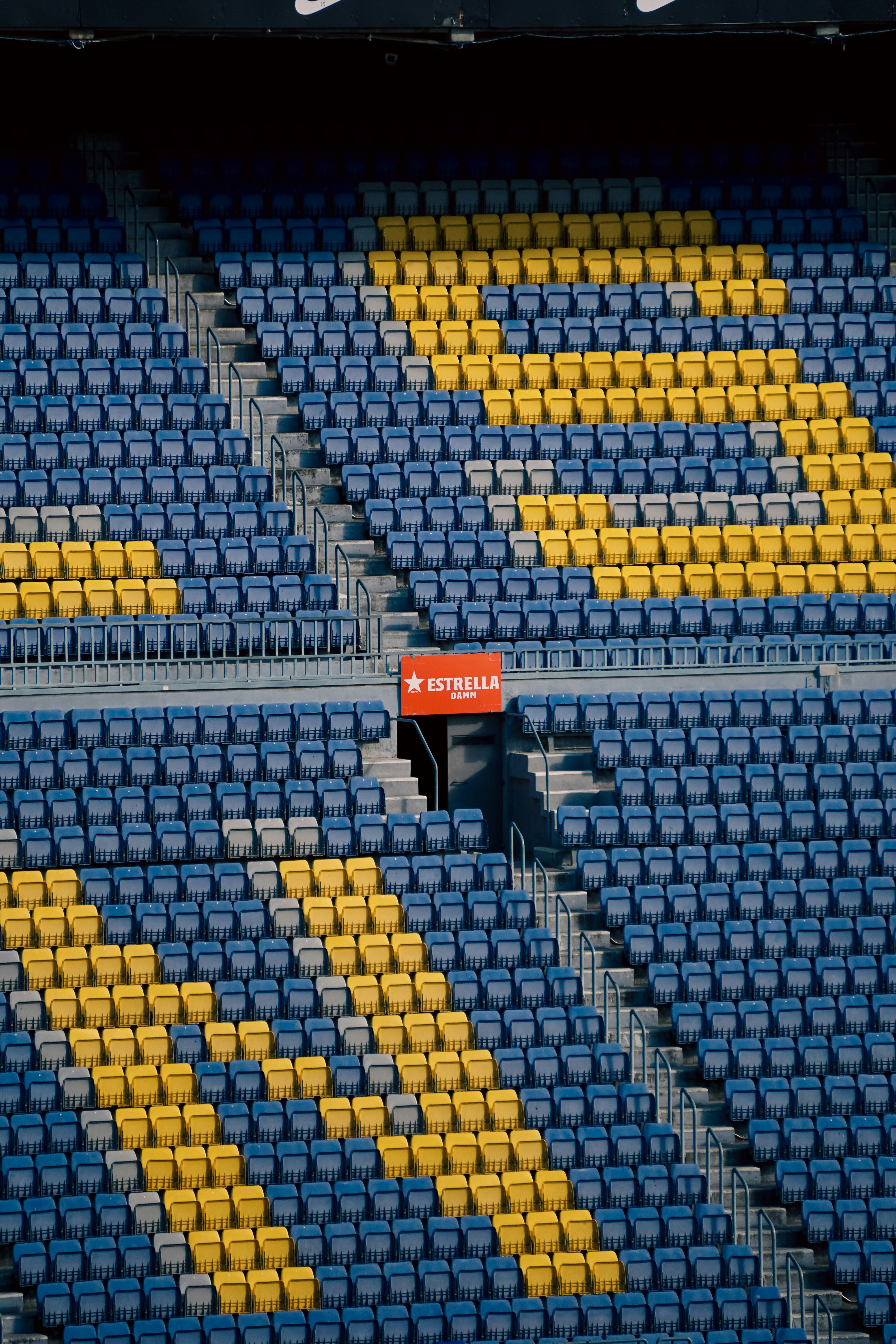 um estádio com assentos azuis e amarelos e uma placa vermelha