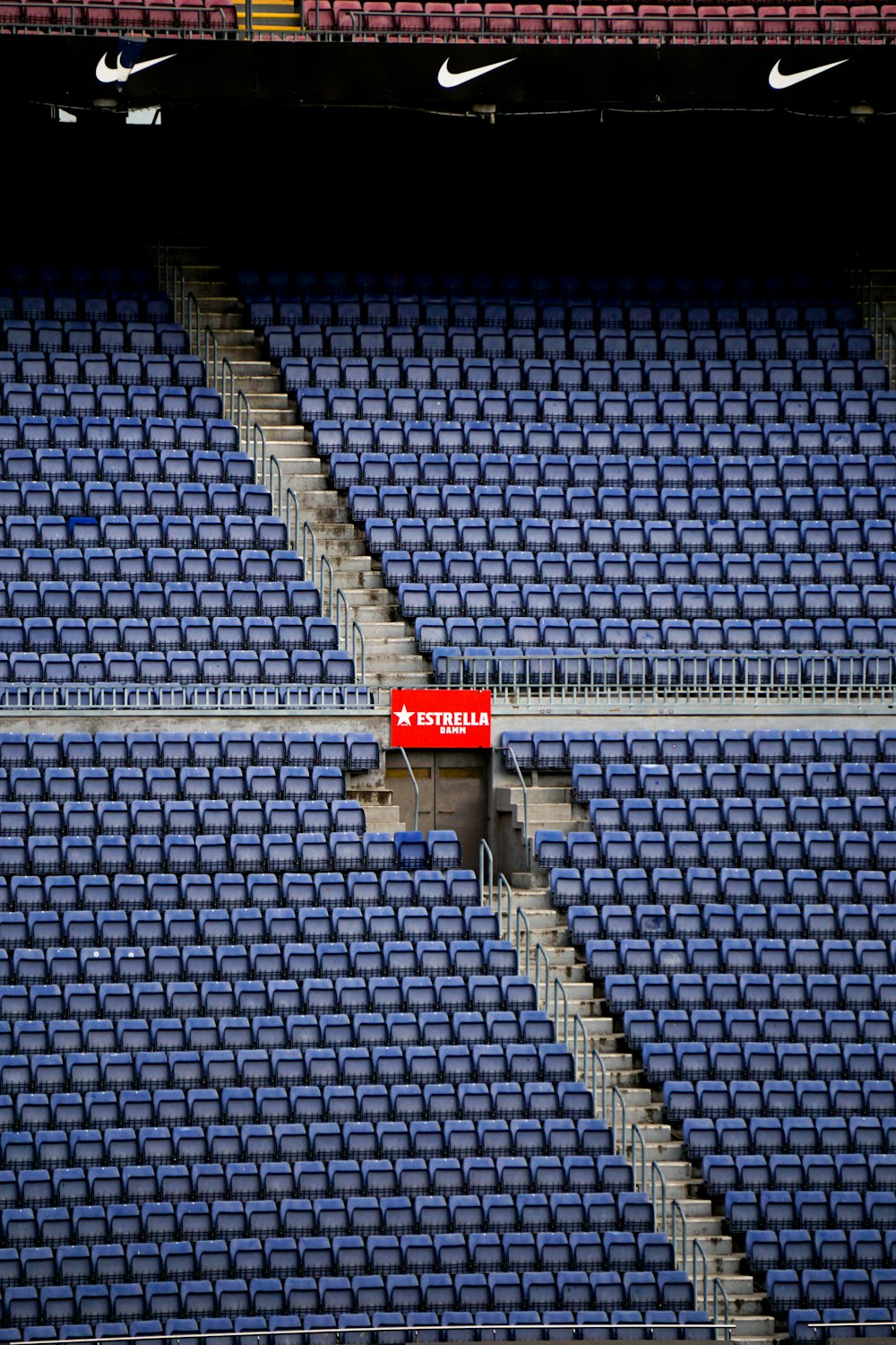 a stadium with blue seats and a red sign