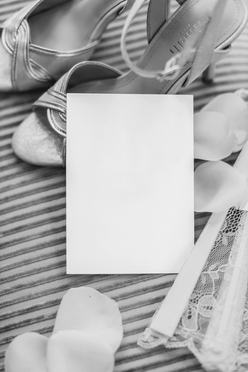 a pair of shoes and a card on a bed